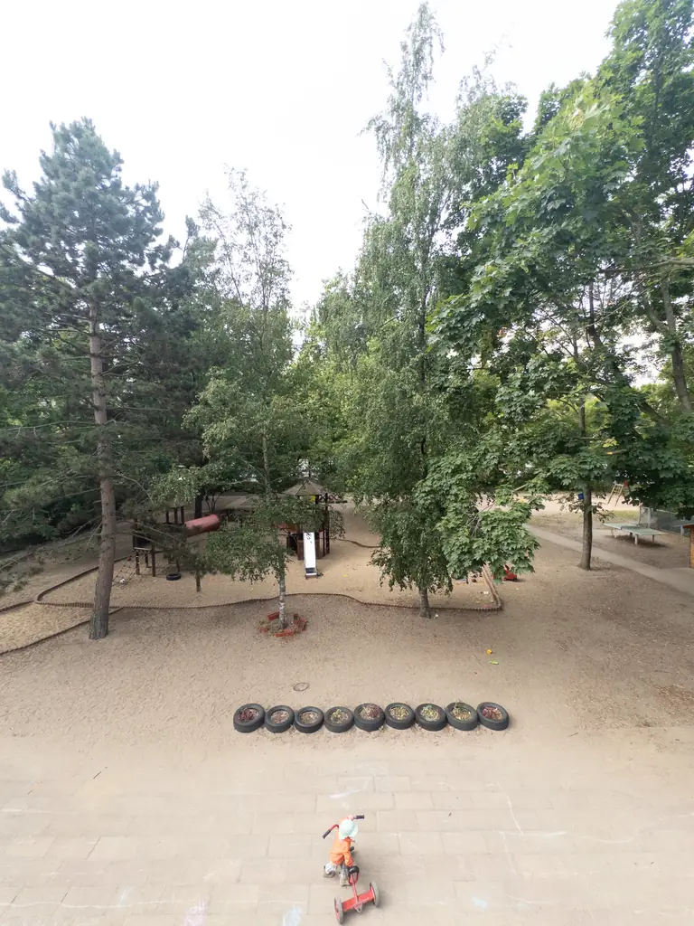 Kind auf dem Dreirad, Blick von oben auf den Spielplatz