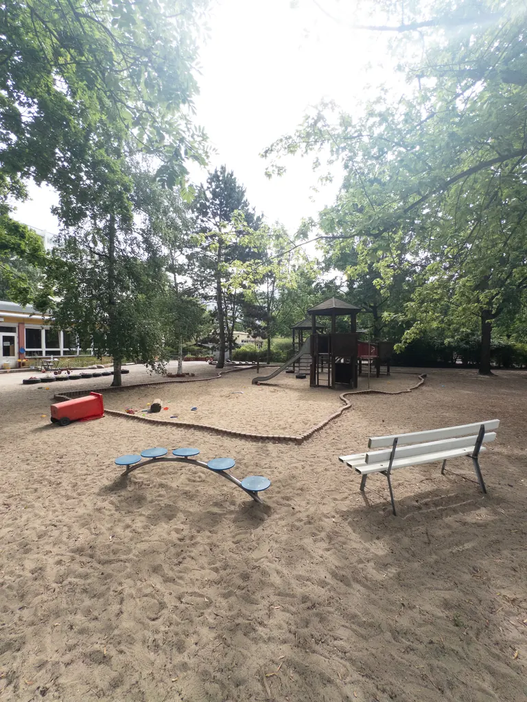 Spielplatz mit Bank und Wippe im Garten